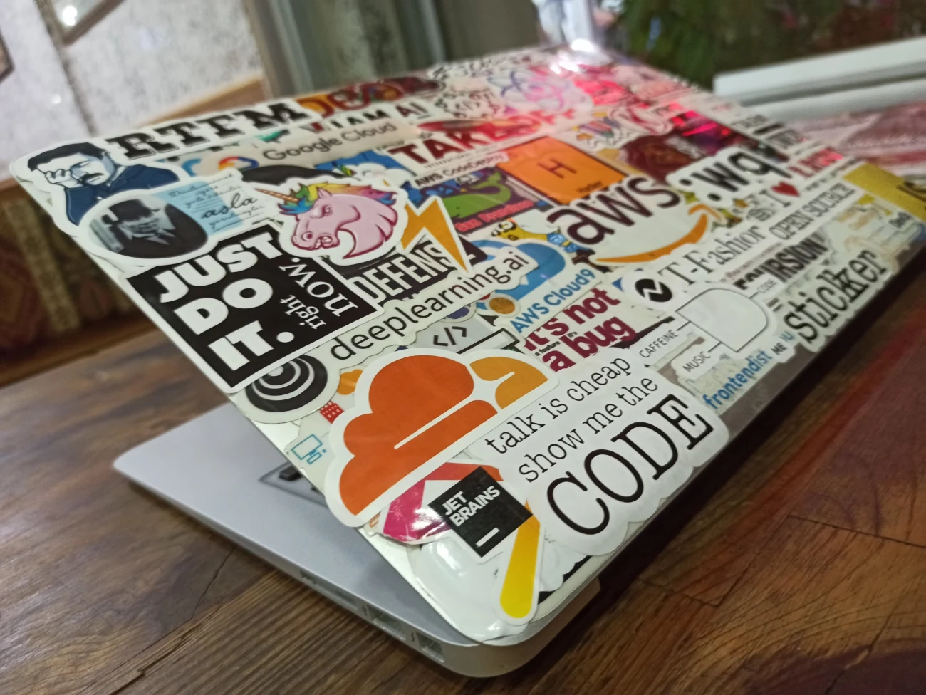 a laptop with a bunch of tech stickers on it